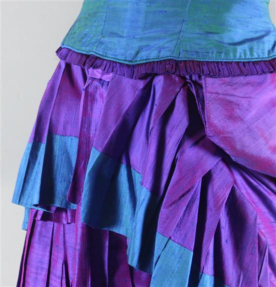 The Merry Widow: A rail with a purple and green dress, two similar dresses in green and brown and gold and